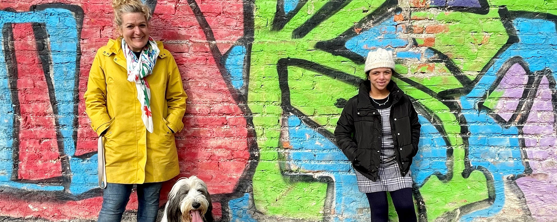 Graffiti Eine Schülerin der Otto-Steiner-Schule steht zusammen mit einer Lehrerin und dem Schulhund vor einer Graffitiwand