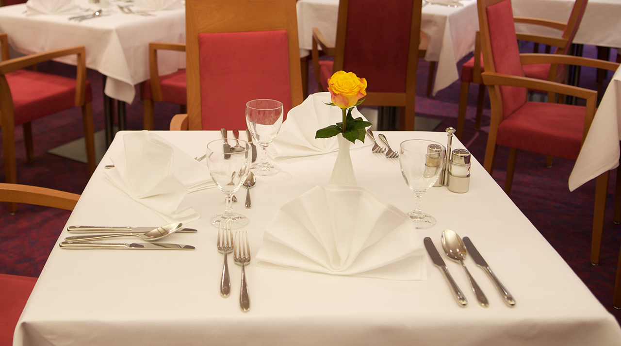 Ein gedeckter Tisch mit einer Rose in einer Vase