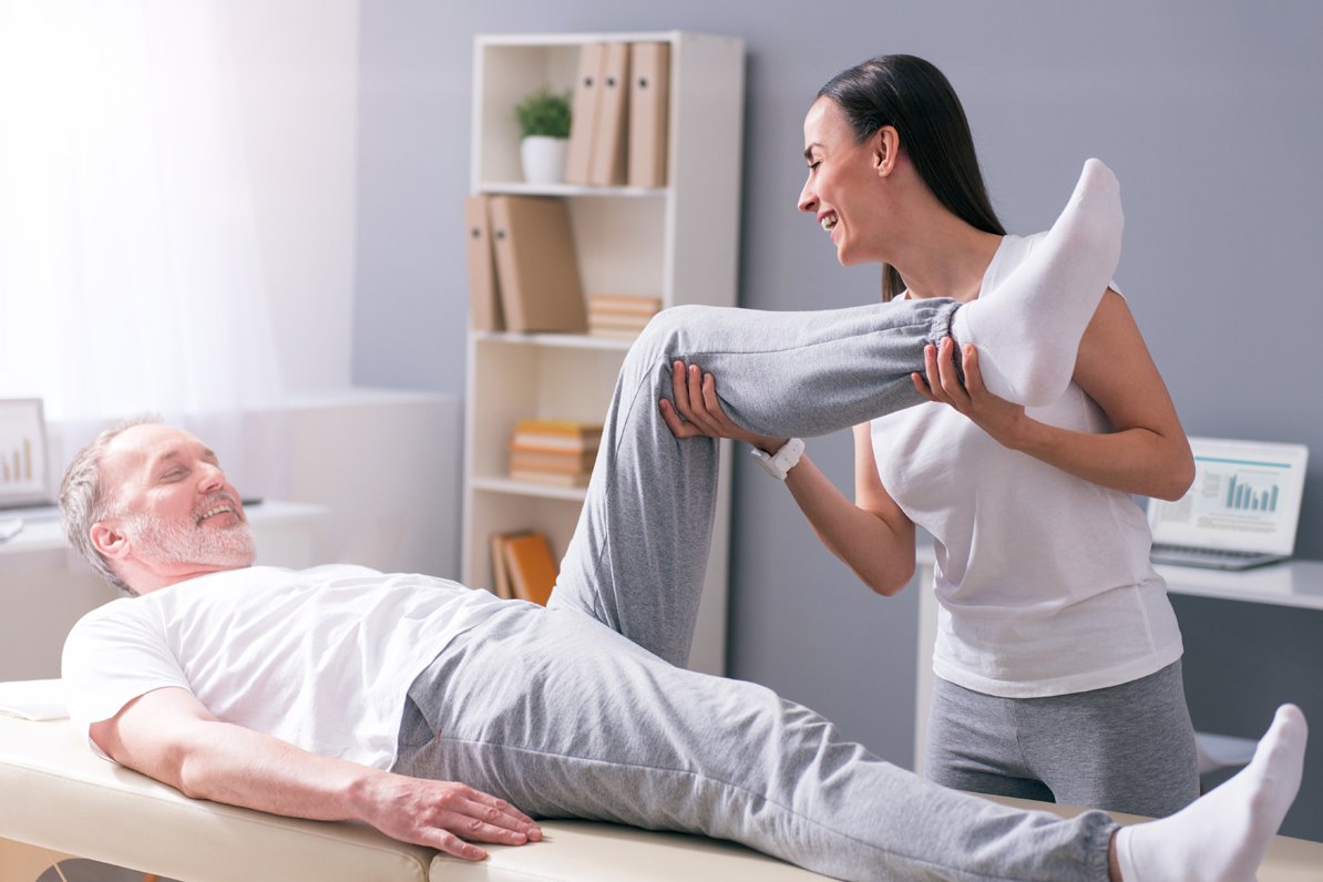 Massagen Eine Physiotherapeutin behandelt einen Patienten