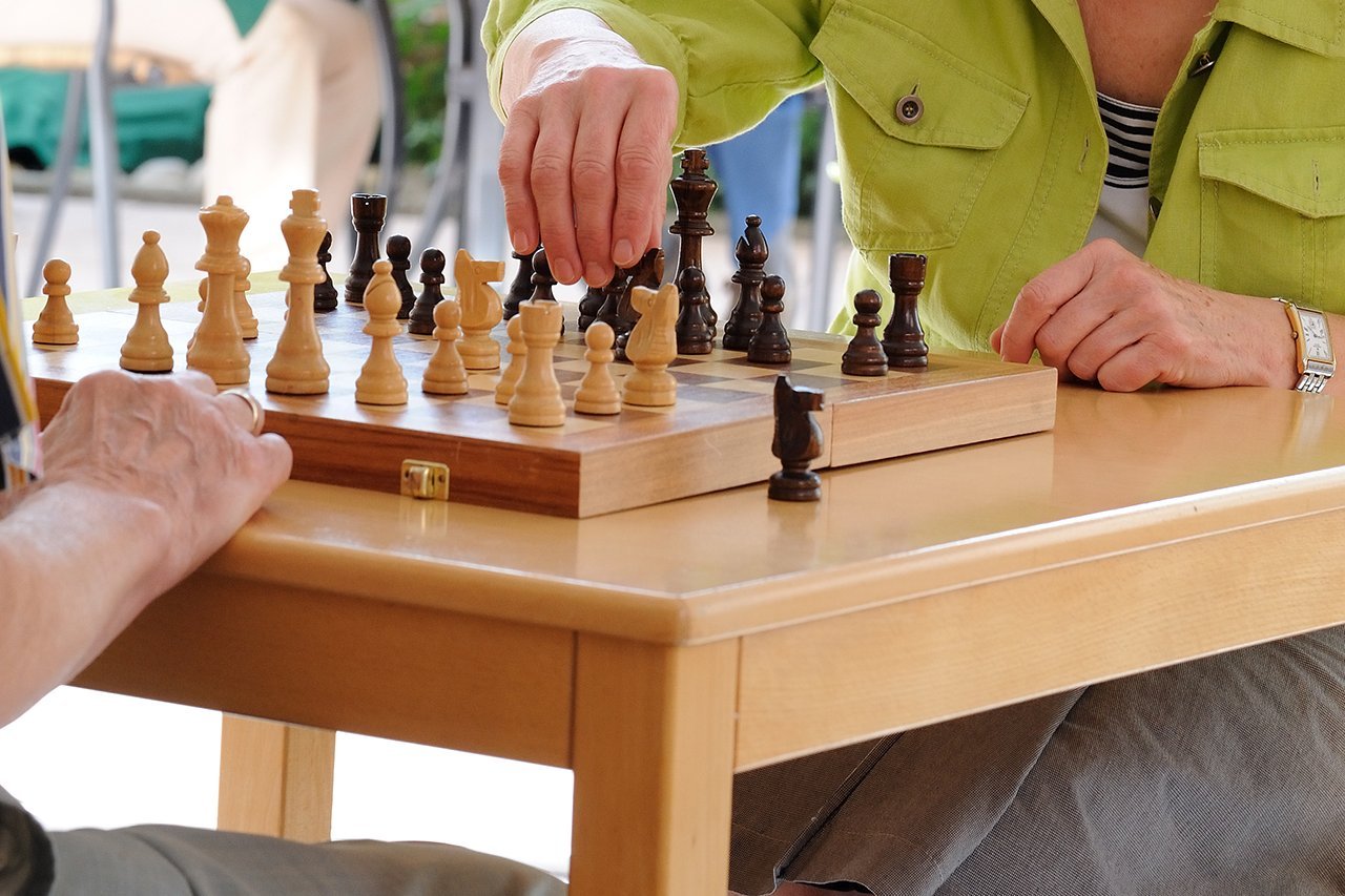 Schach Eine Hand bewegt eine Schachfigur auf dem Schachbrett