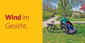 Eine Frau sitzt in einer Fahrradrikscha und winkt. Auf dem Bild ist zu lesen: Wind im Gesicht