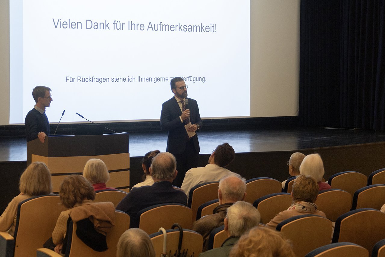 Augustinum Klinik Herzwochen Rückfragen Dr. Friedel und Dr. Husser stehen vor dem Publikum und beantworten am Ende des Vortrags Rückfragen