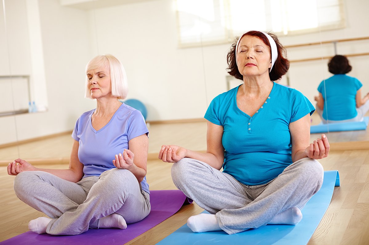 Yoga und Pranayama Zwei Damen im Schneidersitz bei der Meditation
