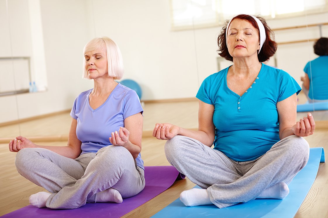 Yoga Zwei Frauen im Schneidersitz
