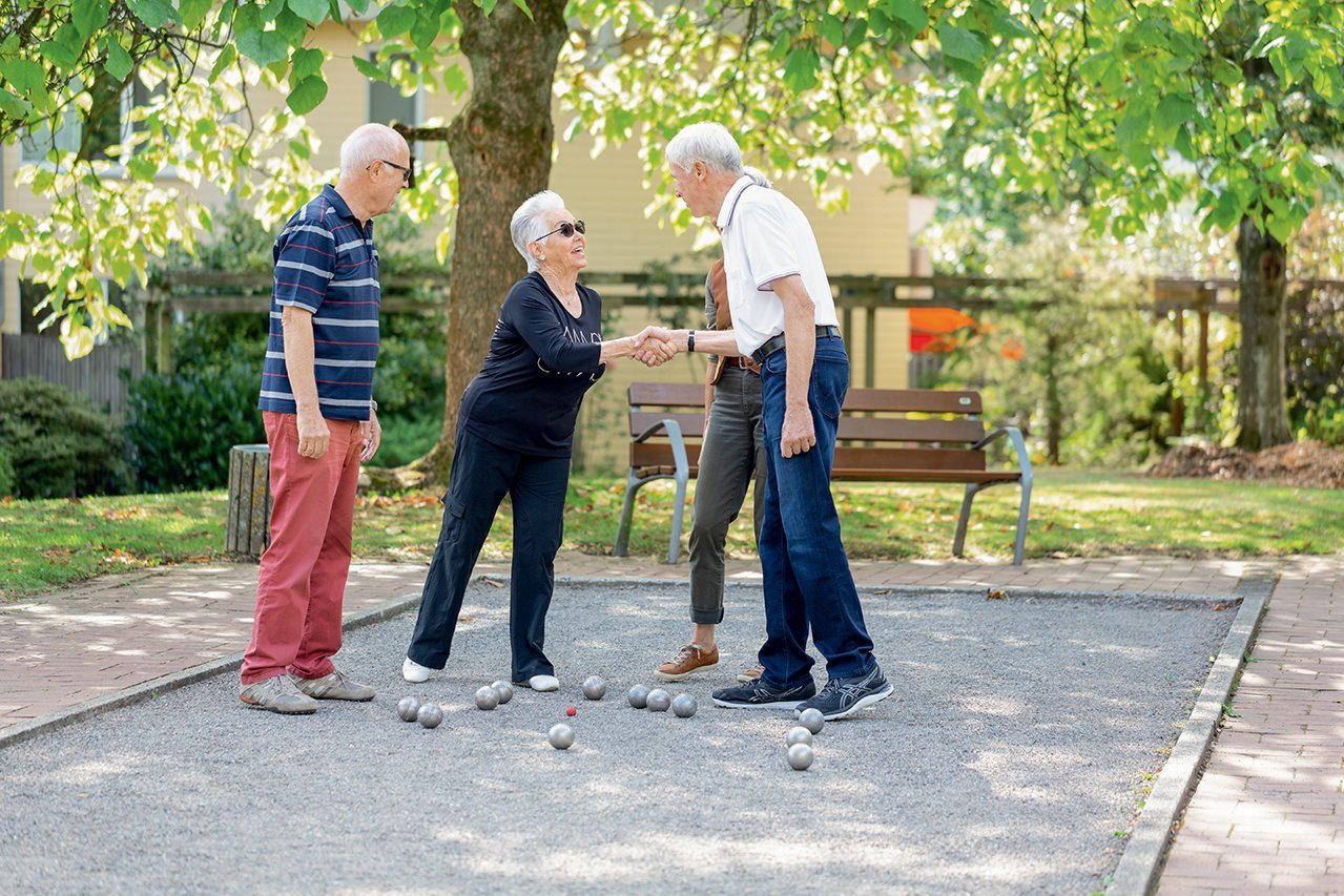 Vier Senior*innen spielen ein Boule-Spiel