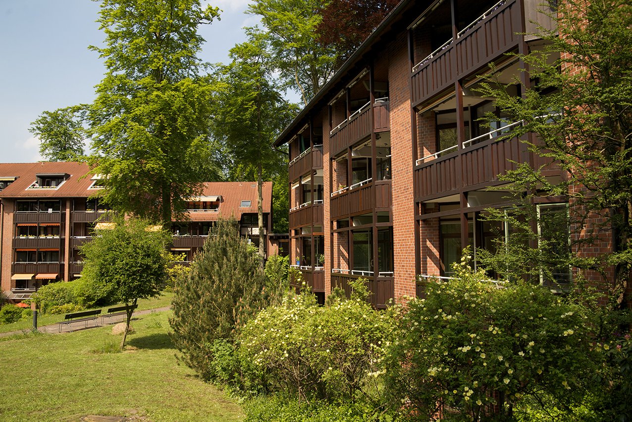 Die im Landhausstil gehaltene Fassade des Augustinum Aumühle fügt sich harmonisch in die weitläufige Parklandschaft mit ihrem alten Baumbestand. Ansicht der Klinkerfassade des Augustinum Aumühle bei Hamburg