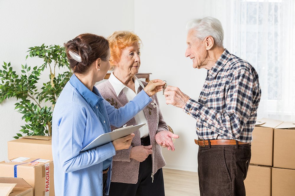 Übergabe der Wohnungsschlüssel an ein älteres Paar