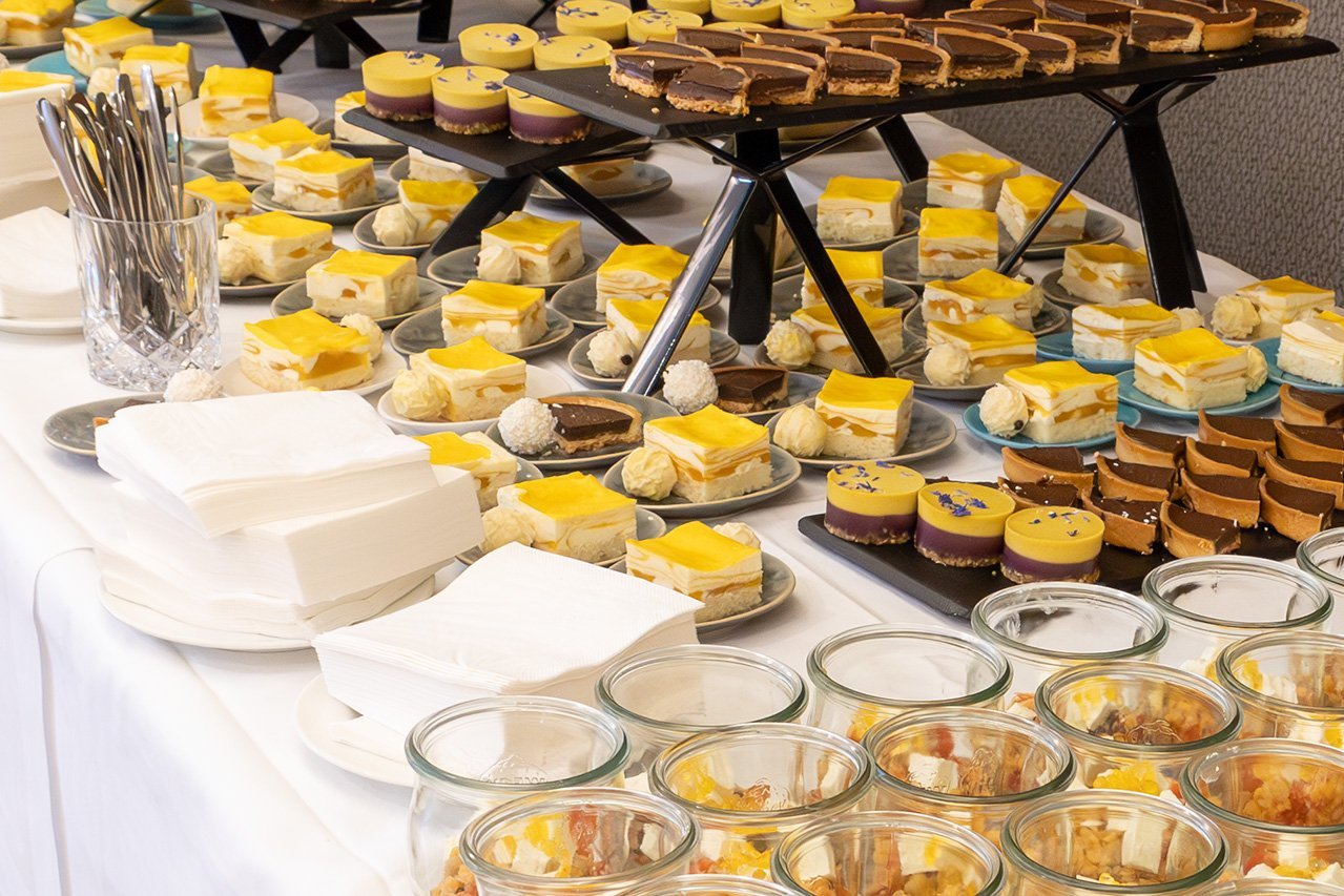 Augustinum Klinik Symposium Catering Viele kleine Kuchen auf einem Tisch beim Büffet der Veranstaltung