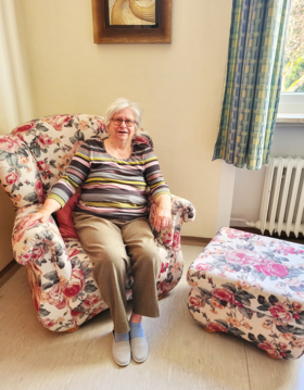 Augustinum Berchtesgadener Land Dagmar Kastner Foto der Bewohnerin Dagmar Kastner, die in einem Sessel sitzt