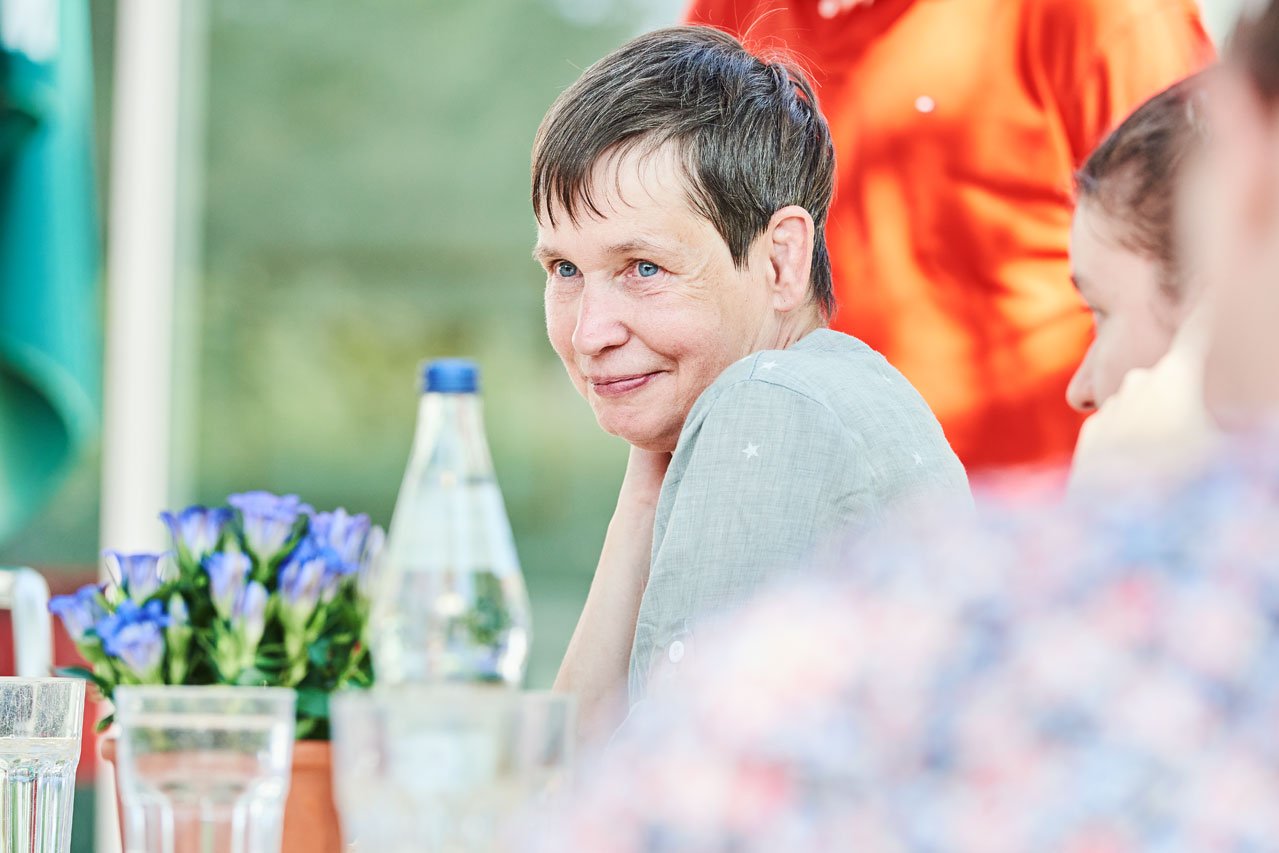Freizeit im Garten Eine Frau sitzt an einem Tisch im Freien