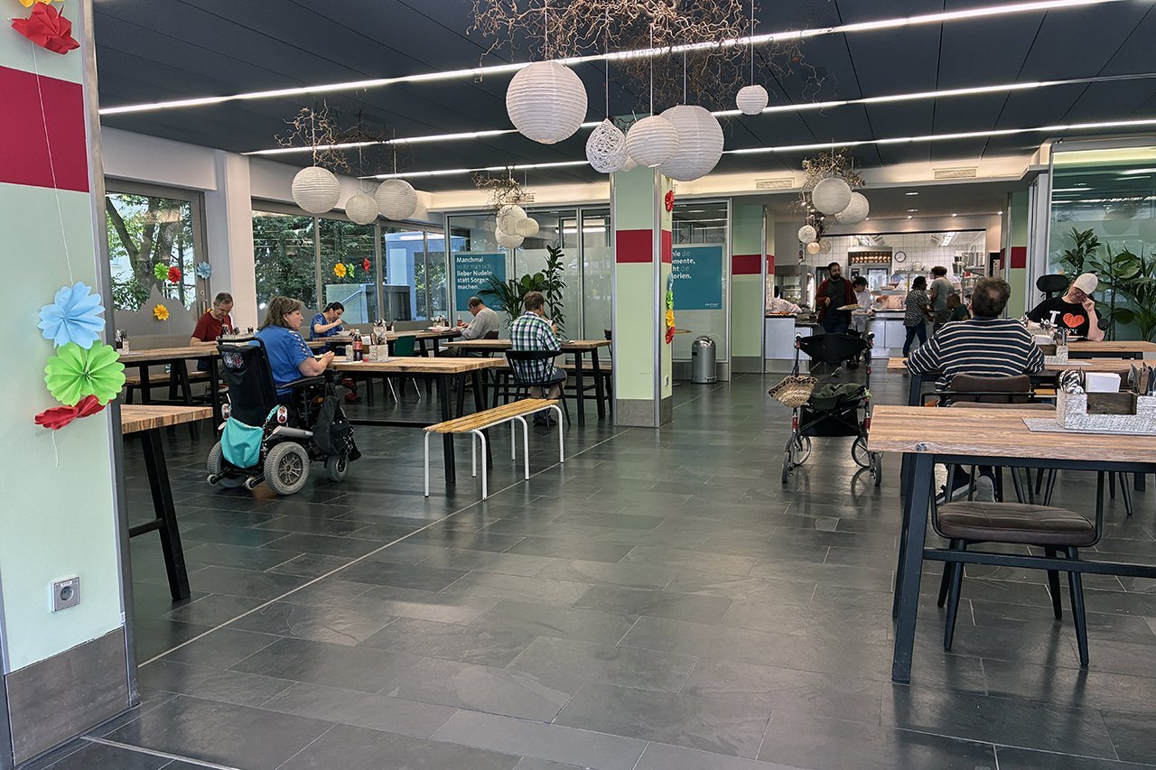 Blick in das "Casino by Augustinum" mit Menschen mit Behinderung, die dort essen