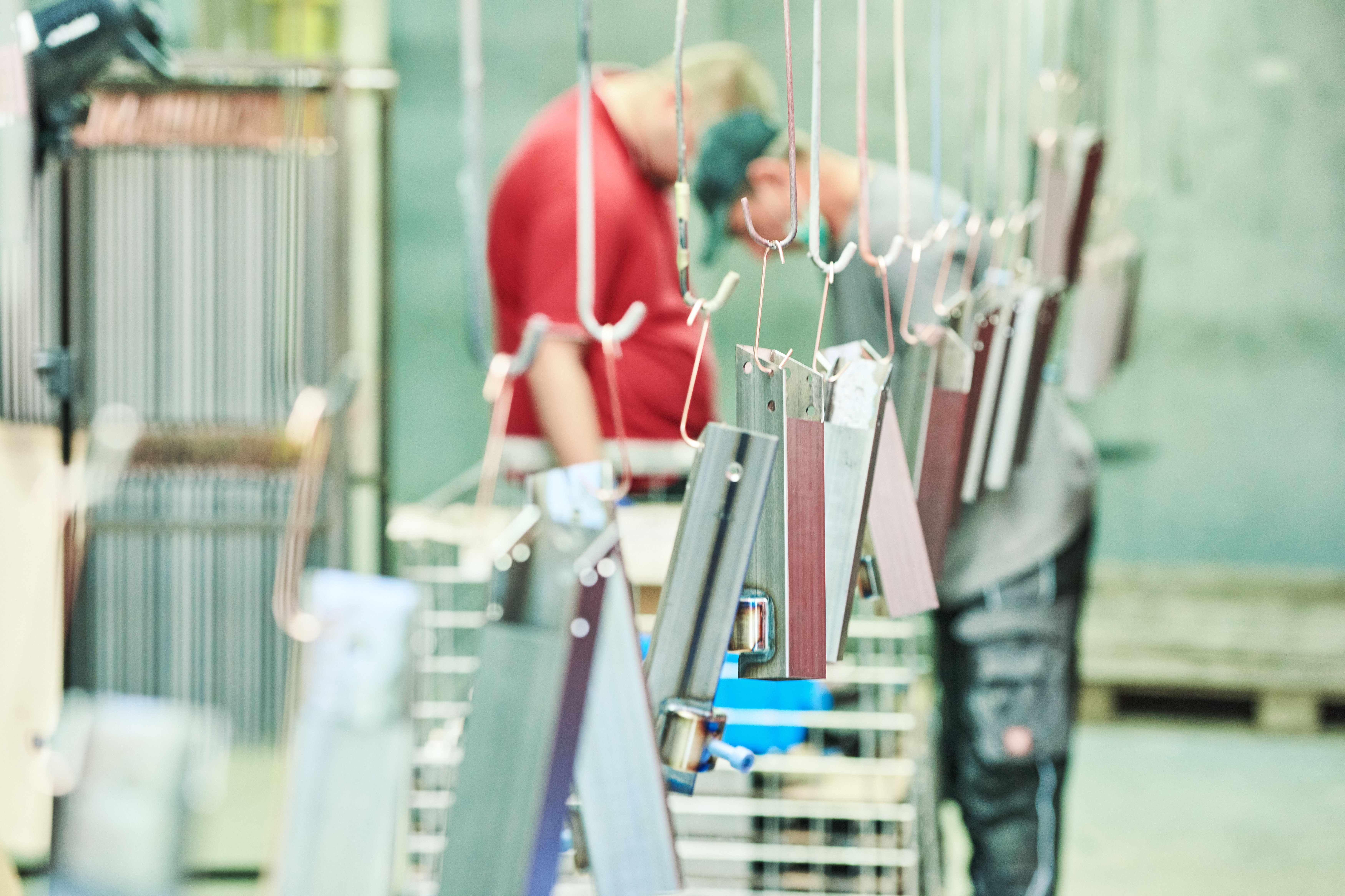 Zwei Klienten bei der Pulverbeschichtung Zwei Klienten bei ihrer Tätigkeit im Bereich Pulverbeschichtung