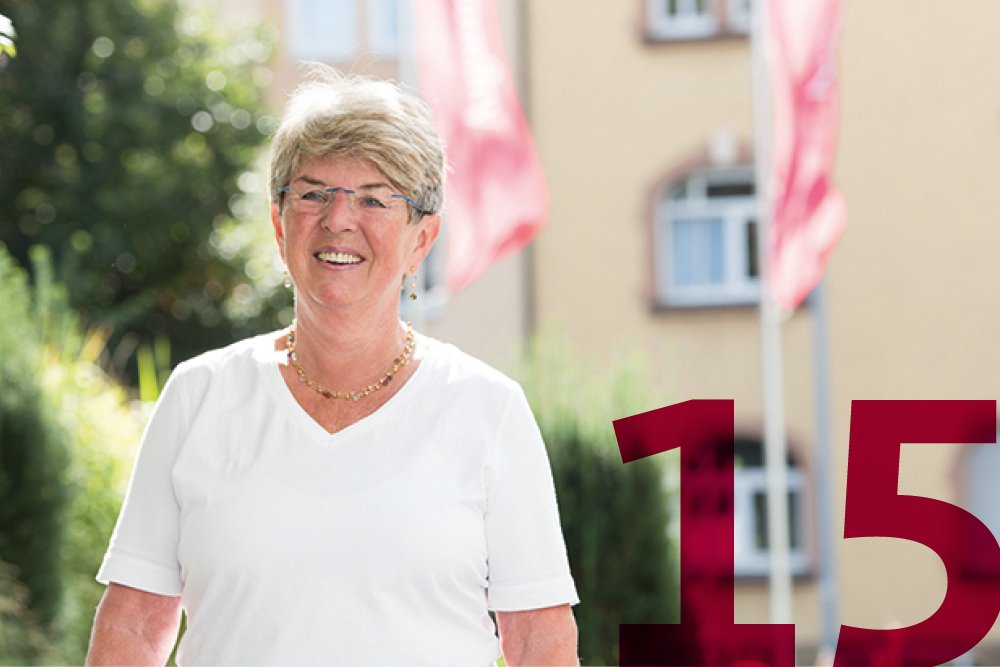 In den Augustinum Seniorenresidenzen leben Sie wie in Ihrer eigenen Wohnung Porträtaufnahme einer Seniorin vor einer Augustinum Seniorenresidenz