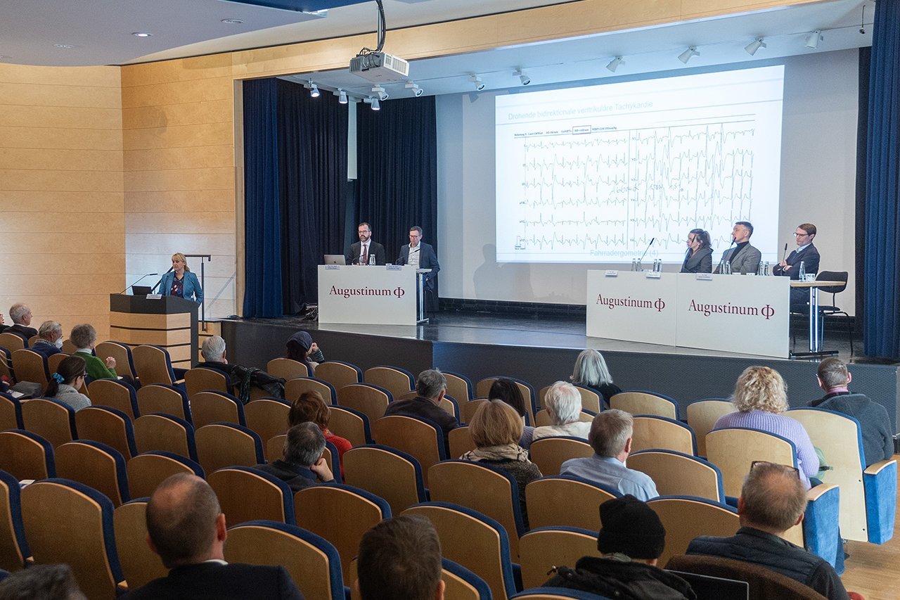 Augustinum Klinik Symposium Dr. Husser-Bollmann Teil des Publikums vor der Referentin Dr. Husser-Bollmann und im Hintergrund sitzen die Leiter der Veranstaltung auf der Bühne