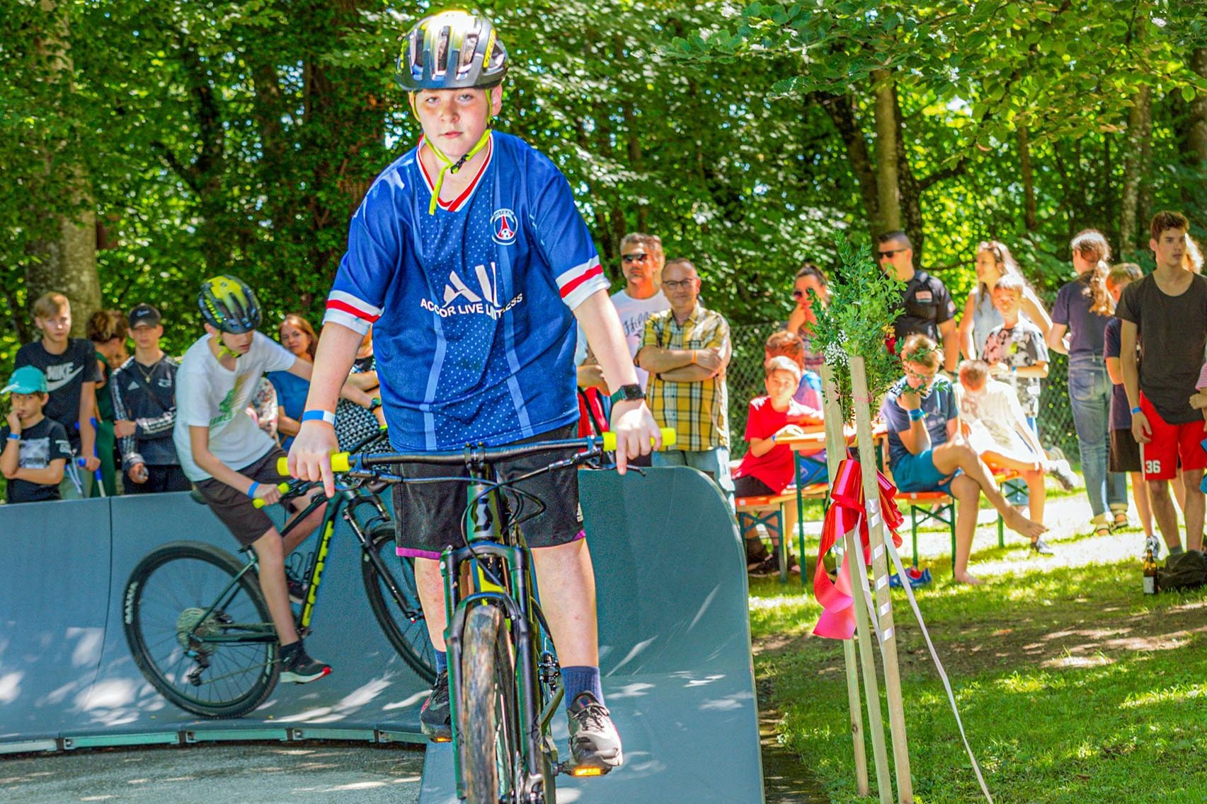 zwei Jungen mit auf Mountainbikes auf einem Pumptrack im Park des Landschulheim Elkofen