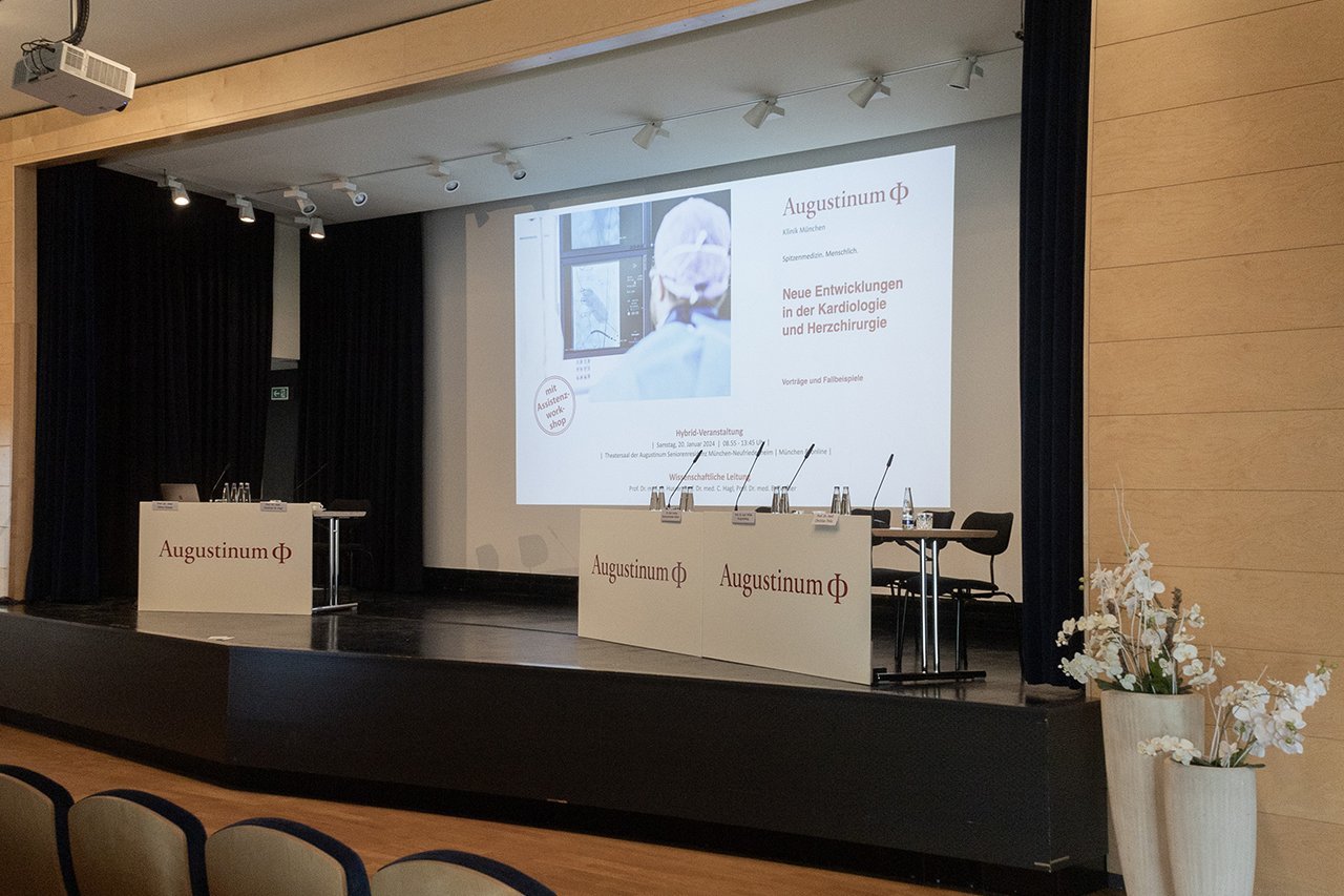 Augustinum Klinik Symposium Stühle und Tische auf einer Bühne im Theatersaal im Augustinum München-Neufriedenheim