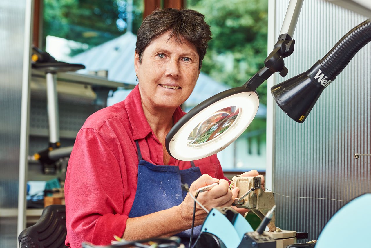 Eine Klientin arbeitet mit einem Vergrößerungsglas in der Elektronikabteilung