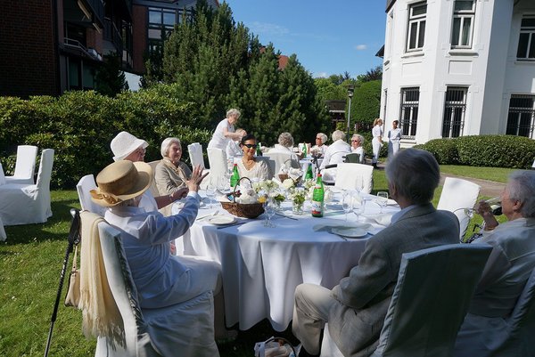 Augustinum Seniorenresidenz Aumühle Feste und Feiern 3 Senior*innen sitzen draußen an großen Tischen und feiern ein Fest