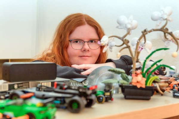 Augustinum Adipositas Wohngruppen Maite Das Mädchen steht hinter einem Regal, auf dem sich viele Deko-Artikel befinden, und blickt in die Kamera
