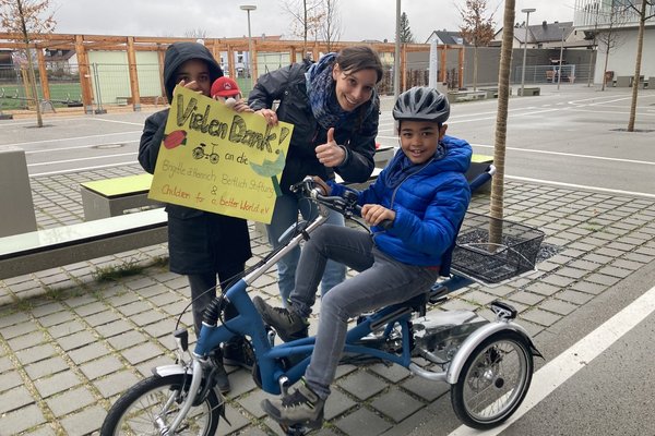 Augustinum Spenden Verkehrsunterricht Zwei Schüler und eine Lehrerin halten beim Verkehrsunterricht ein Plakat in den Händen, auf dem sie sich für die Spenden bedanken