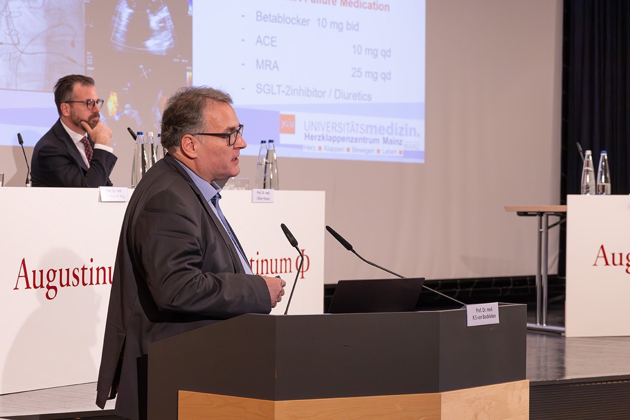 Augustinum Klinik Symposium von Bardeleben Nahaufnahme des Referenten Dr. von Bardeleben am Rednerpult vor der Bühne
