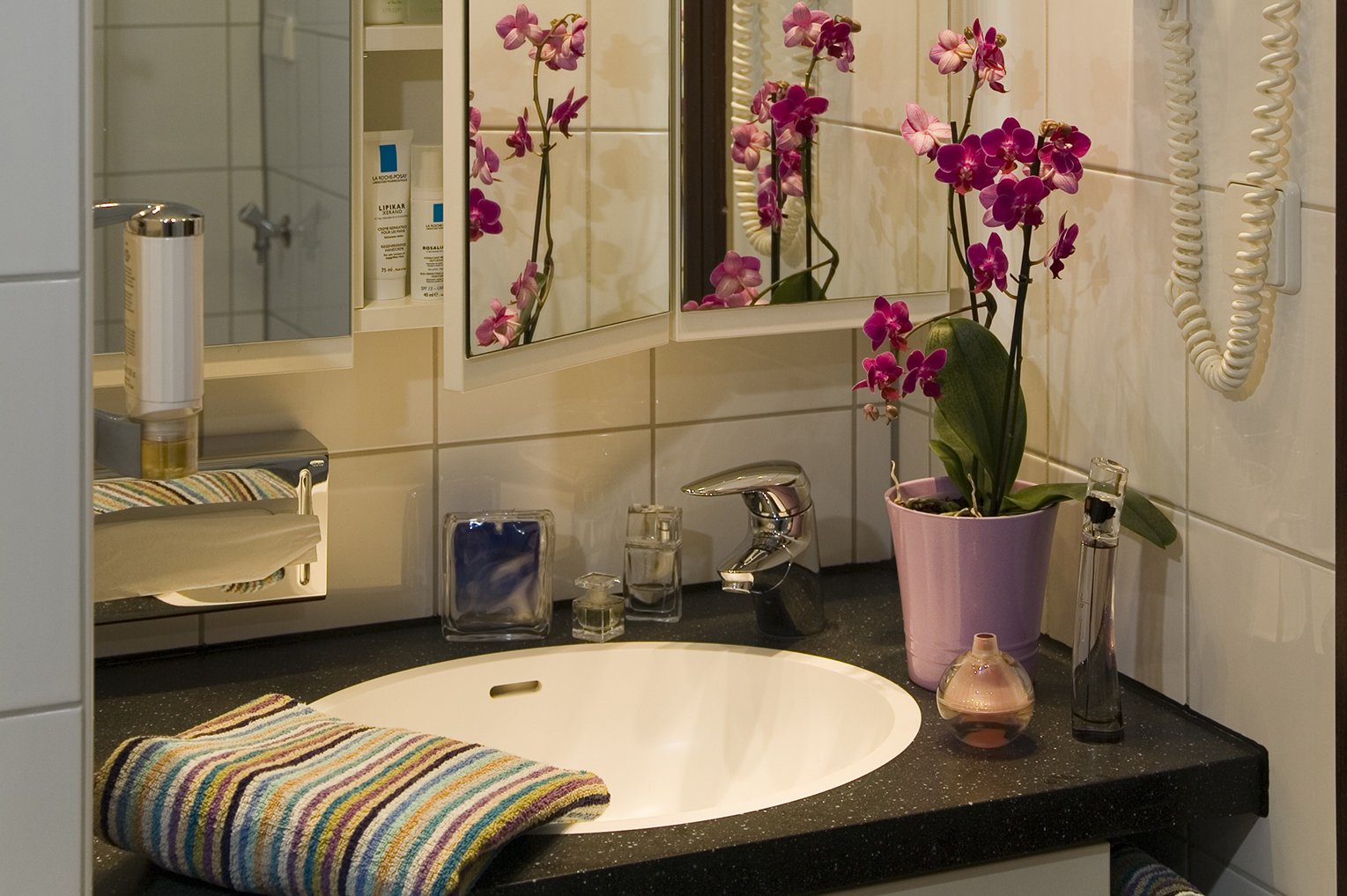 Badezimmer mit Dusche, modernen Armaturen und Spiegelschrank.