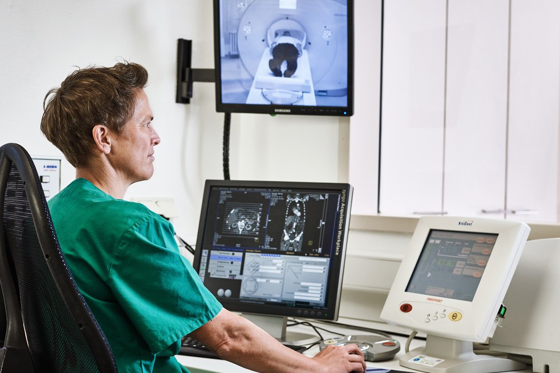 Computertomographie Eine Mitarbeiterin der Augustinum Klinik kontrolliert vor mehreren Bildschirmen sitzend eine Computertomographie