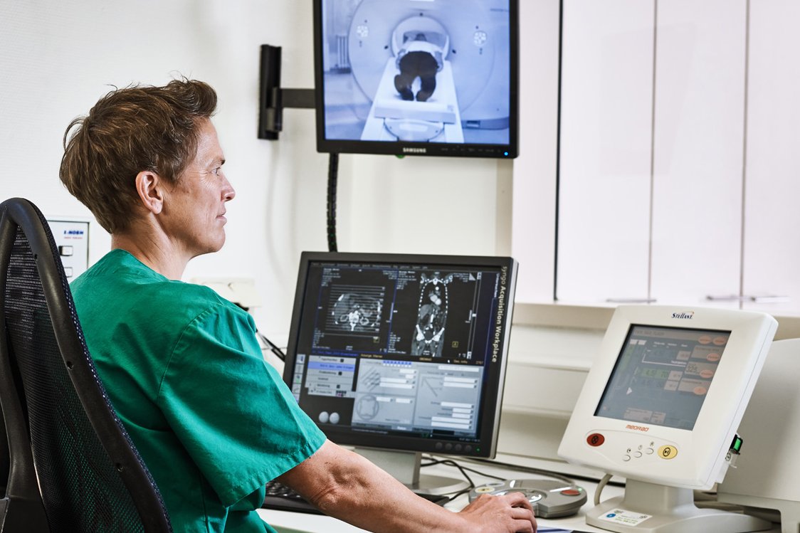 Computertomographie Eine Mitarbeiterin der Augustinum Klinik kontrolliert vor mehreren Bildschirmen sitzend eine Computertomographie