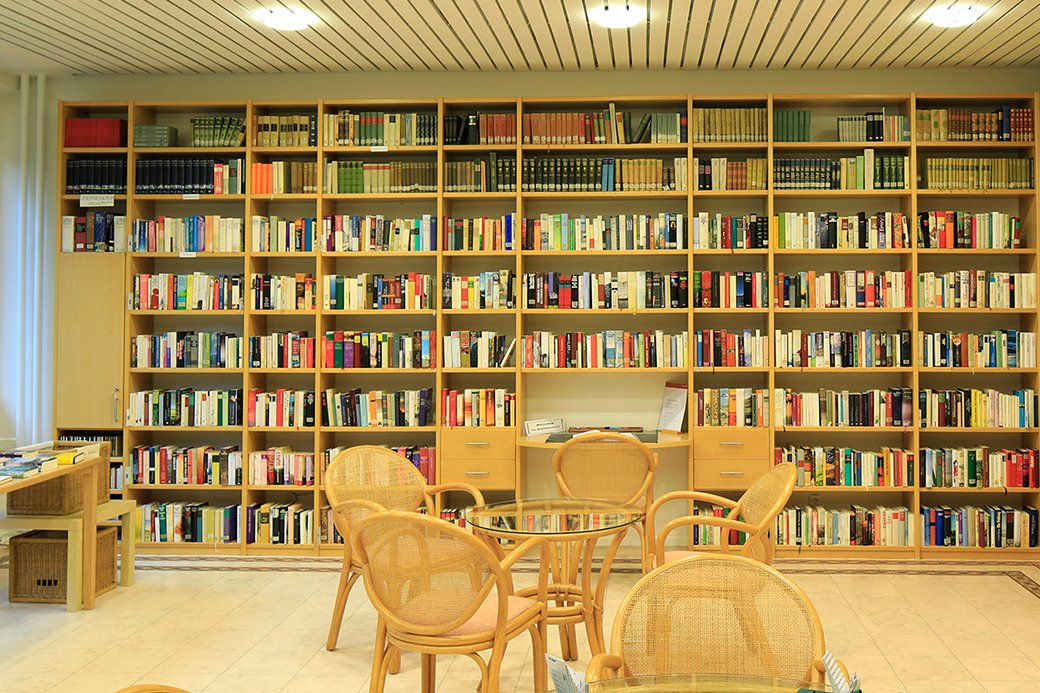 Bibliothek mit Stühlen und Bücherregal