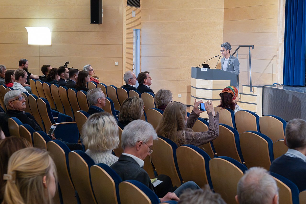 Augustinum Klinik Symposium Chun Eine Aufnahme des vorderen Teil des Publikums und dem davor referierenden Dr. Chun am Rednerpult