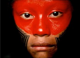 Tukano & Kayapó: Zwei Indianerkulturen im Vergleich Nahe Portraitaufnahme einer amazonischen Einwohnerin mit auffälliger roter und schwarzer Gesichtsbemalung.