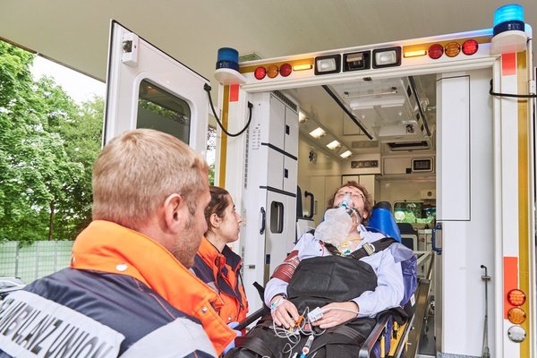 Zwei Sanitäter befördern jemanden aus dem Rettungswagen 