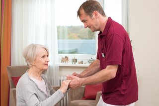 Ein Pfleger des Augustinum betreut eine Seniorin