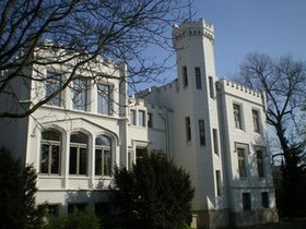 Ein weißes Gebäude mit Zinnen vor einem blauen Himmel