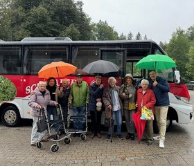 Augustinum Berchtesgadener Land Jenner Senior*innen und Mitarbeiter*innen des Augustinum Berchtesgadener Land stehen mit Regenschirmen vor einem Kleinbus