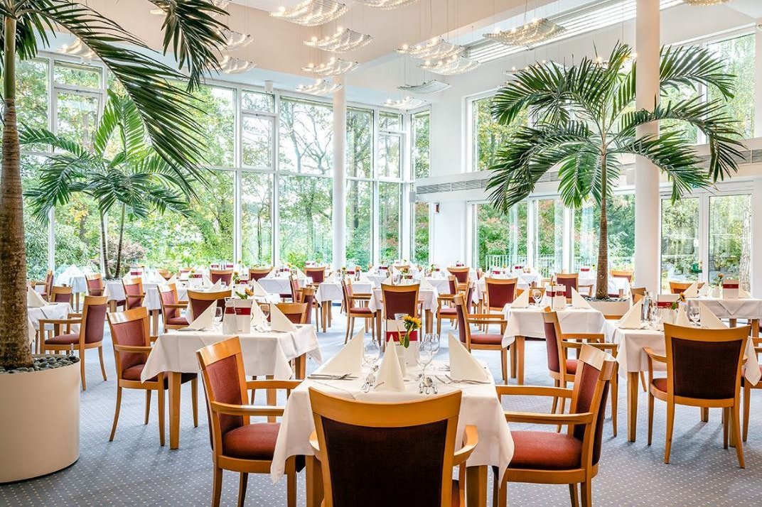 Gedeckte Tische in einem Restaurant mit großen Fenstern 