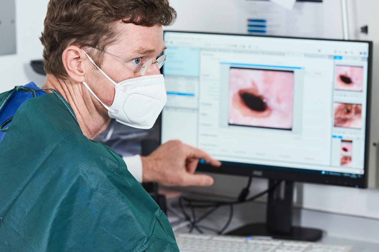 Endoskopieaufnahmen Ein Arzt sitzt vor einem Monitor mit endoskopischen Aufnahmen und erläutert das GEzeigte.