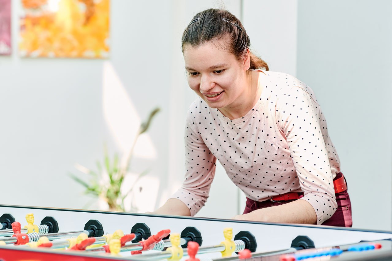 Tischfußball Eine Klient*in spielt Tischfußball