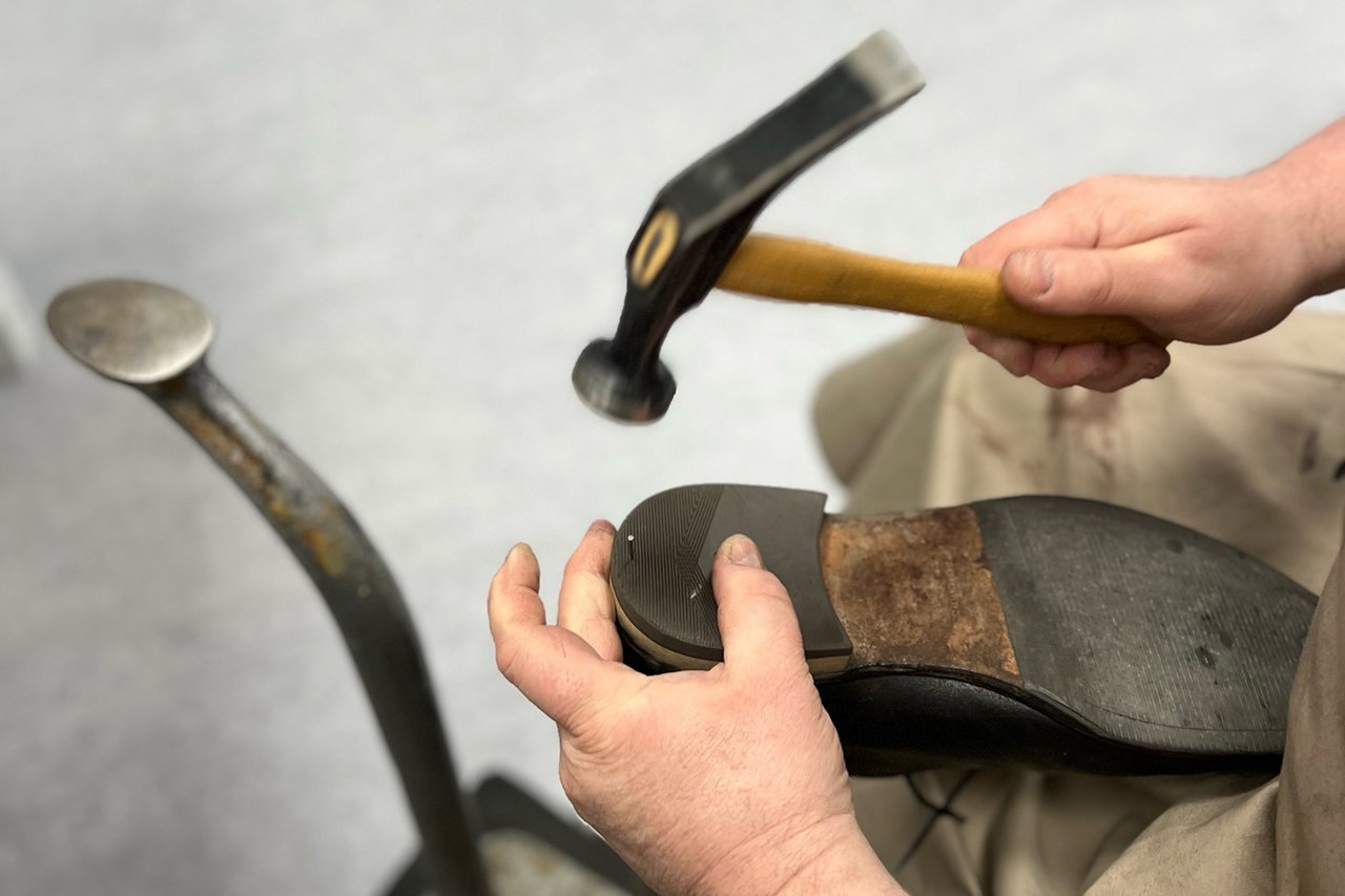 Ein erneuerter Absatz wird an dem Schuh fixiert
