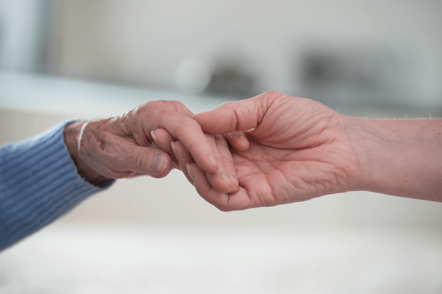 Wertschätzende individuelle Betreuung und Versorgung Junge Hand, die alte Hand hält