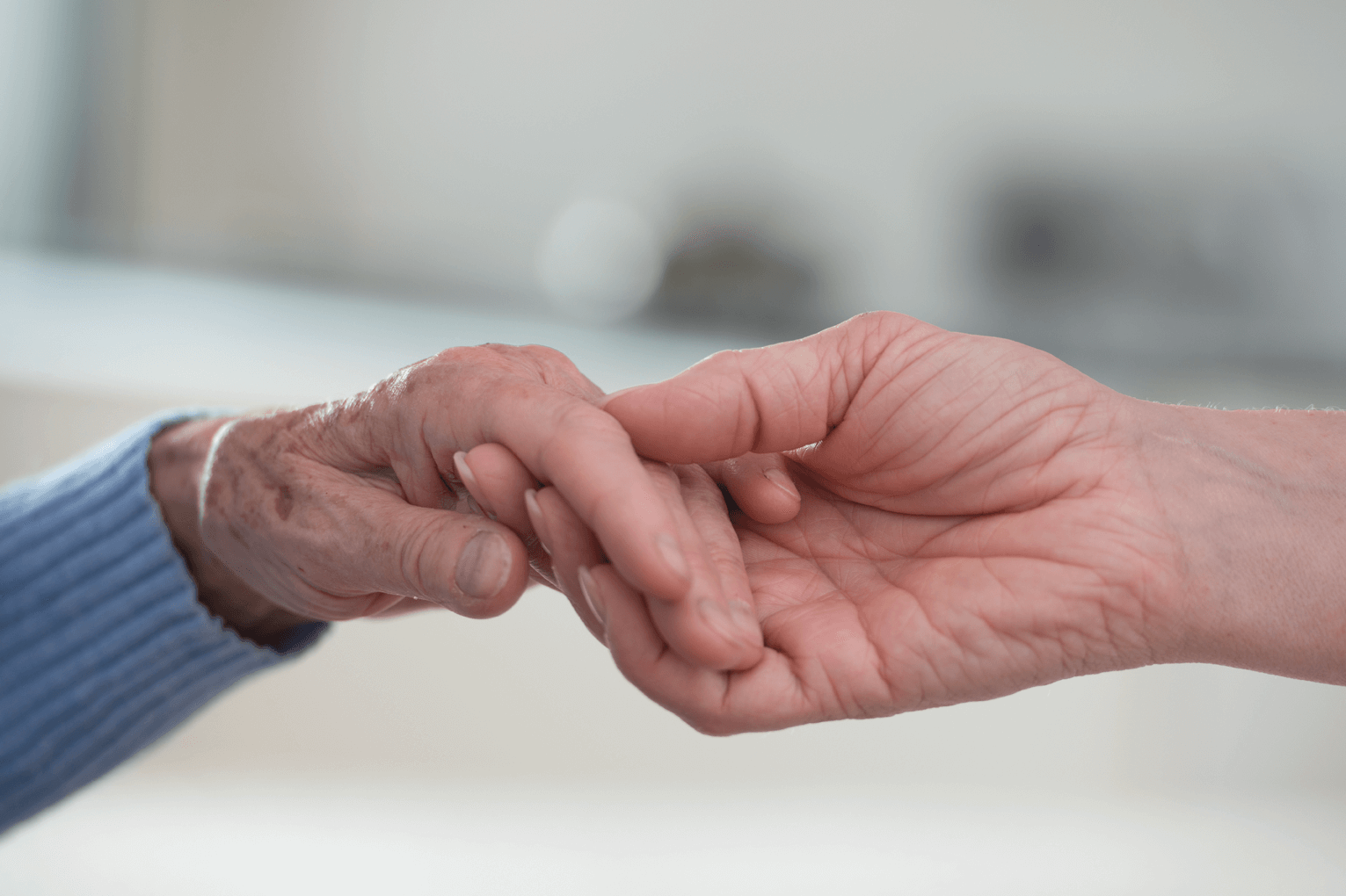 Junge Hand, die alte Hand hält