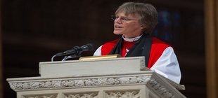 Frau in Messgewand am Rednerpult