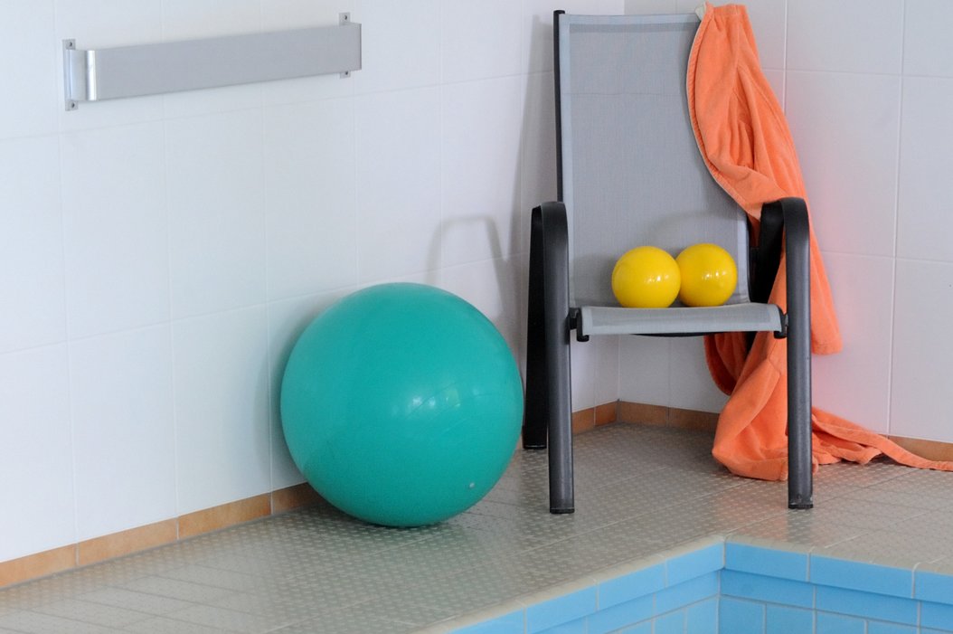 Wassergymnastik Gymnastikbälle am Rand eines Schwimmbeckens