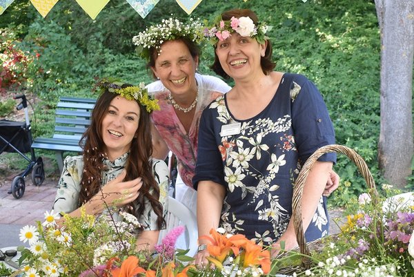 Feste und Feiern Drei Mitarbeiterinnen des Augustinum mit Blumenkränzen beim Mittsommer-Fest