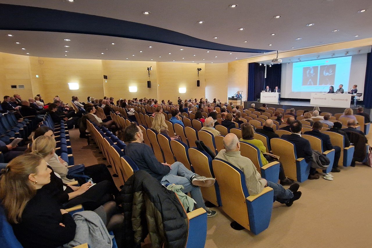 Augustinum Klinik Symposium Eine seitliche Ansicht der von den Teilnehmer*innen besetzten Stühle im Theatersaal