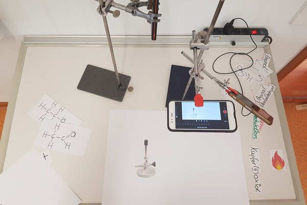 Ein Smartphone filmt die darunterliegende Fläche von oben
