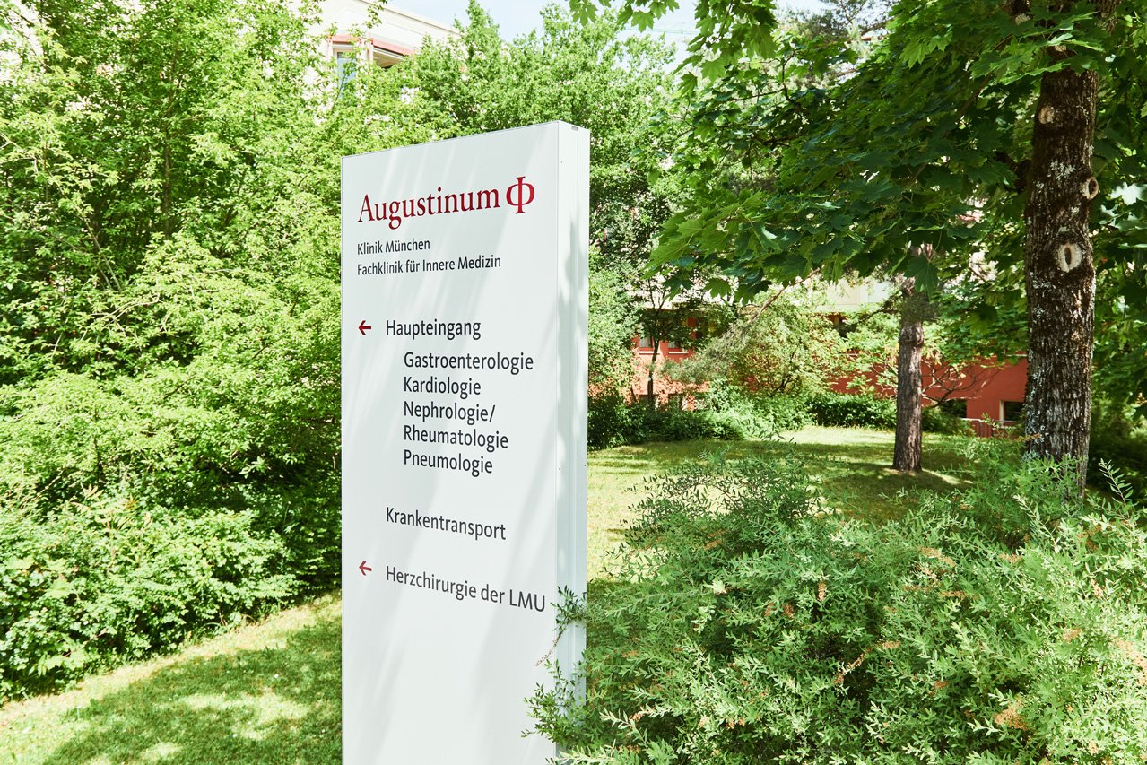 Ein Bild des Wegweisers vor der Augustinum Klinik mit einem Link zur Seite für Patienten