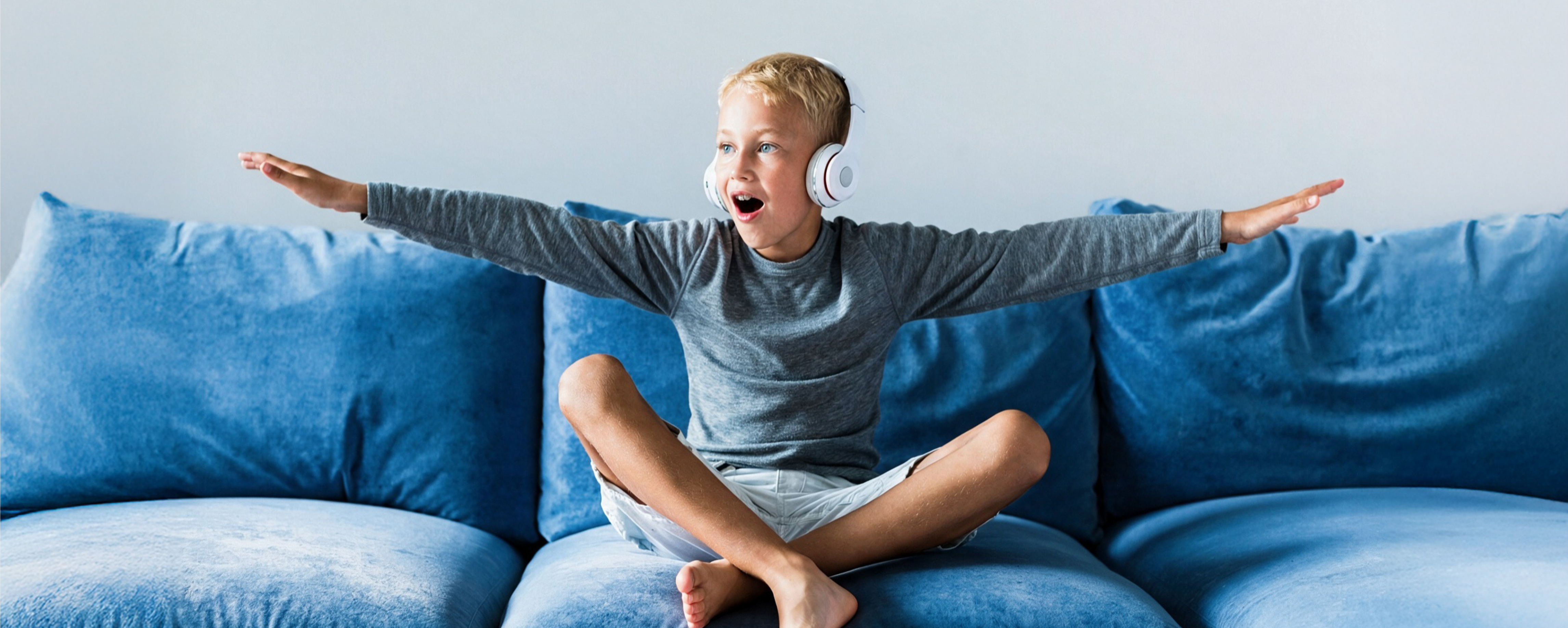 junge mit kopfhörerb sitzt auf blaer couch47
