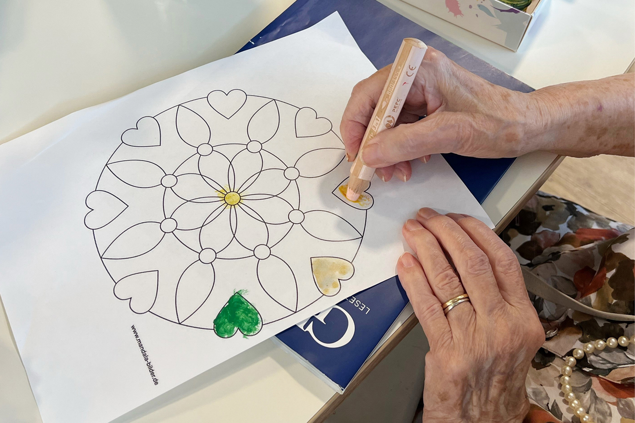 Augustinum Tagespflege Mandala Eine Seniorin malt ein Mandala aus